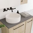 Modern bathroom vanity with round sink, black fixtures, and minimalist design.