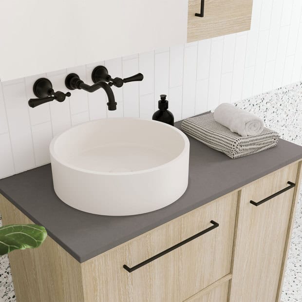 Modern bathroom vanity with round sink, black fixtures, and minimalist design.